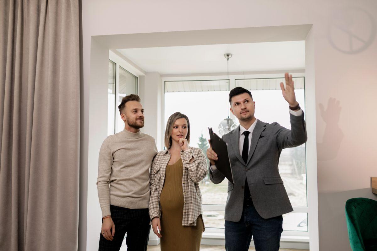 An estate agent showing a couple around a bright home